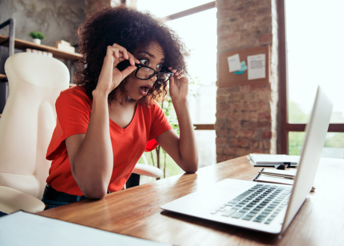 terrified woman staring at computer screen